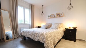 A bedroom with a large bed, two bedside tables, a mirror, and a window with curtains. - Holiday rental with pool in the Alpilles for 6 people (Plan-d´Orgon)