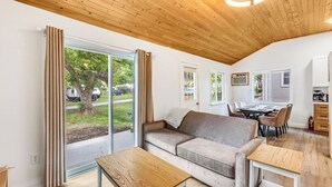Un espacio acogedor con sofá, una mesa de madera y una mesa de comedor con sillas.