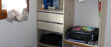 A bedroom with a bed, a wardrobe, and a suitcase.