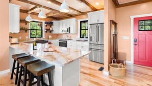 Una cucina moderna con un'isola grande, elettrodomestici in acciaio inossidabile e pavimento in legno.