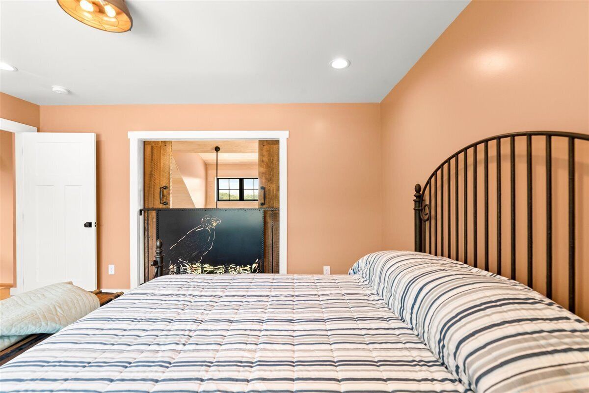 Un dormitorio con una cama, una puerta y vistas a un pasillo.