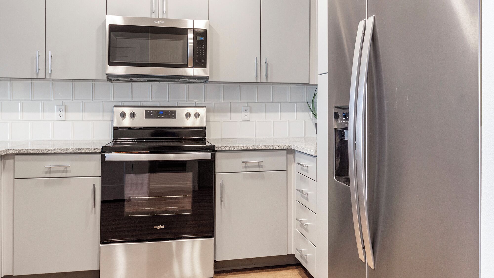 A kitchen with stainless steel appliances, including a microwave, oven, and refrigerator.