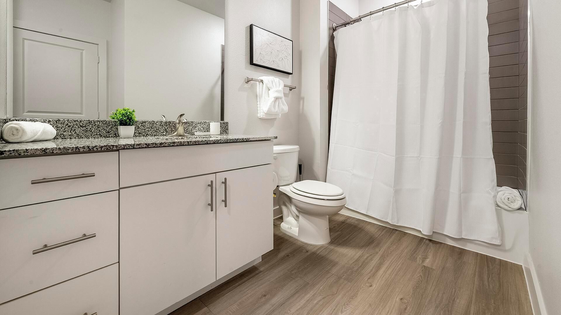 A modern bathroom with a toilet, sink, and shower area.