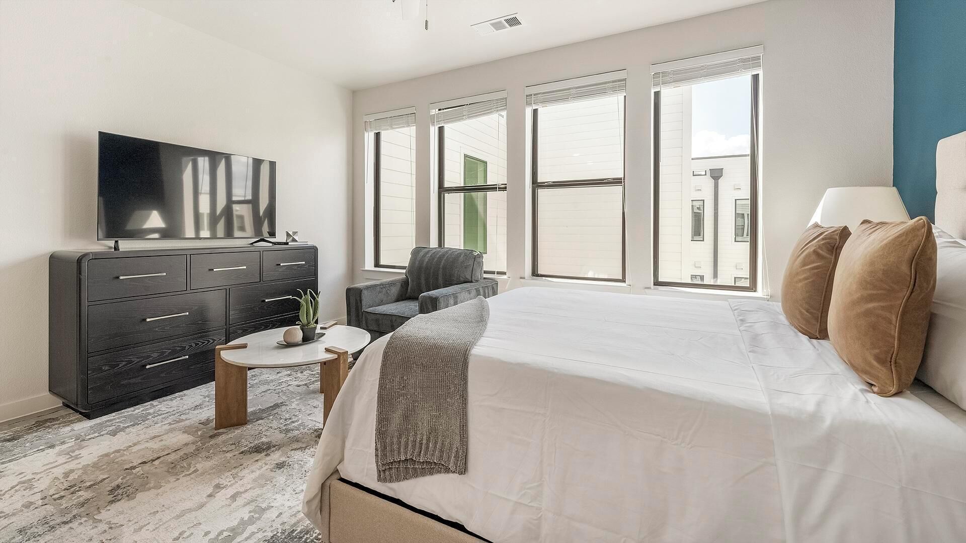 Een moderne hotelkamer met een groot bed, een flatscreen televisie, een bureau en een stoel.