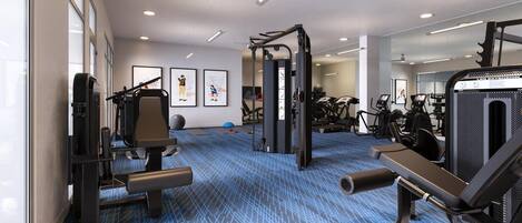 Un gimnasio con máquinas de cardio, equipo de levantamiento de pesas y un espejo grande.