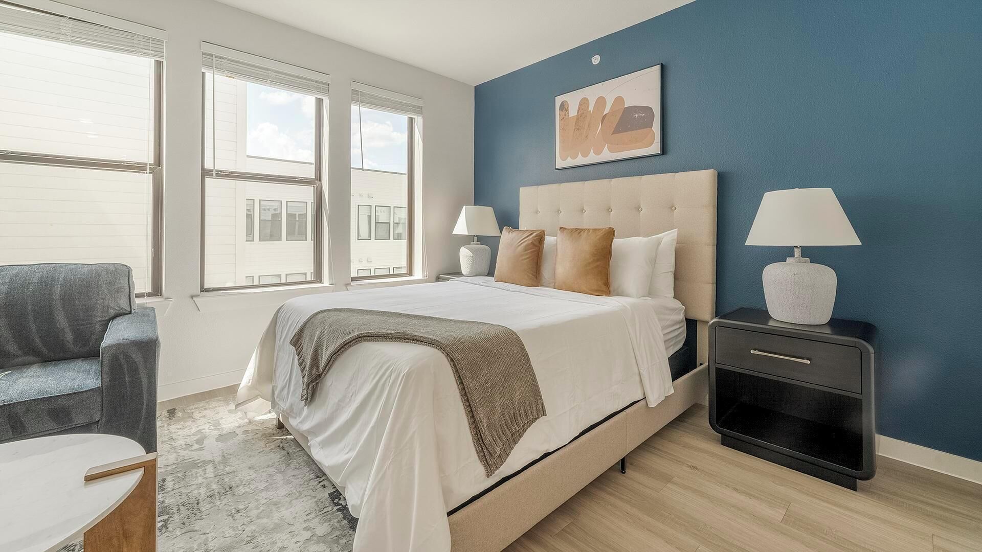 A bedroom with a bed, bedside tables, a chair, and a window.