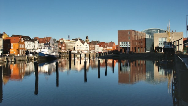 A calm waterfront with buildings and a boat docked. - Hekmat Apartments Fernsicht Schobüll (Husum)