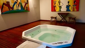 A room with a hot tub, wooden flooring, and two paintings on the walls. - Luxor Tambaú (João Pessoa)