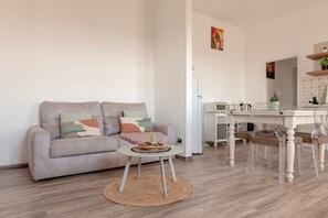 Una sala de estar con sofá, una mesa de centro y un comedor con sillas y una mesa.