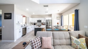 Eine moderne Wohnung mit Küche, Essbereich und Wohnzimmer.
