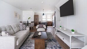 A modern living room with a sofa, coffee table, and TV. - Landing Furnished Apartments - Billings, MT (Billings)