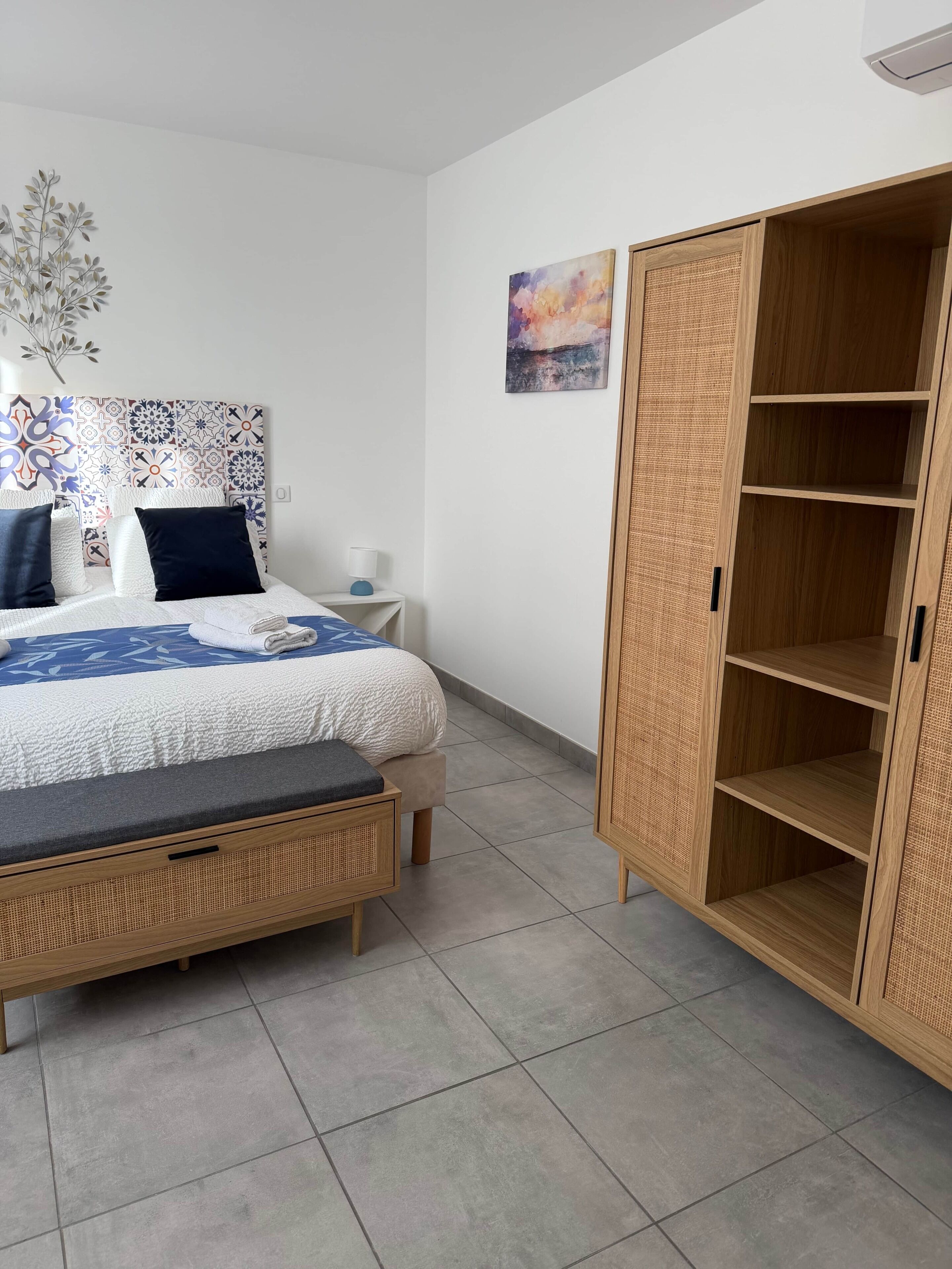 A bedroom with a bed, bedside table, and a wardrobe.