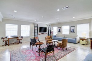 Un salón amplio con sofá, sillones, una mesa de centro, televisor y chimenea.