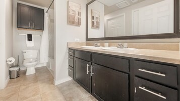 Un baño con inodoro, lavabo y espejo.