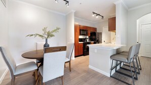 Una cocina moderna con armarios de madera, un refrigerador negro y un microondas.