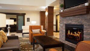 A modern living room with a fireplace, comfortable seating, and a flat-screen TV. - Studio Suite in Houston's Energy Corridor | Free Breakfast + 24h Business Center (Houston)