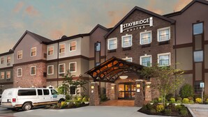 A Staybridge Suites hotel with a brick facade, multiple windows, and a covered entrance. - Studio Suite in Houston's Energy Corridor | Free Breakfast + 24h Business Center (Houston)