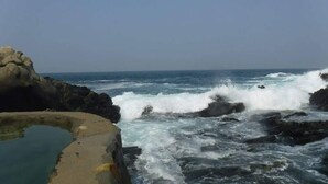 Una costa rocciosa con onde che si infrangono sulla riva.