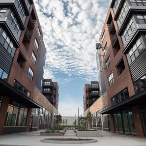 Een modern gebouw met een symmetrische gevel, grote ramen en een centrale binnenplaats.