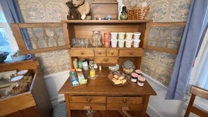 A wooden kitchen counter with jars, bottles, and food items.