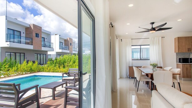 A modern apartment with a balcony, a dining area, and a kitchen. - Three-bedroom villa with private pool (Punta Cana)