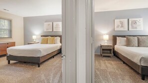 Ein Schlafzimmer mit einem großen Bett, einem Nachttisch, einer Kommode und einem Spiegel.