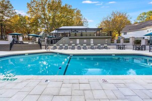 Una piscina al aire libre de temporada, sillones reclinables de piscina