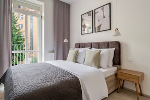 A bedroom with a bed, a nightstand, a window with curtains, and two framed pictures on the wall. - Blueground | Nusle, balcony, quiet, nr Vysehrad (PRG-64) (Prague)