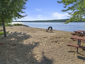 A sandy beach with picnic tables and a tire swing. - Lakefront on Como - Lake Geneva -Walk to Beach (Lake Geneva)