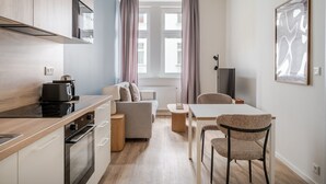Ett modernt kök med en inbyggd ugn, en kaffemaskin och en matplats med bord och stolar.