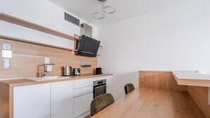 Eine moderne Küche mit einer Holz Arbeitsplatte, integrierten Geräten und einem Essbereich mit Holztisch und Stühlen.