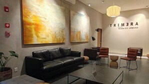 Ein modernes Wohnzimmer mit einem schwarzen Ledersofa, einem Glastisch und einem großen abstrakten Gemälde an der Wand.