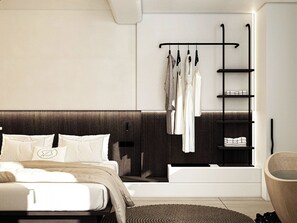 A modern bedroom with a bed, a bedside table, a wall-mounted shelf with clothes, and a built-in bathtub. - Mamay Hotel (Santorini)