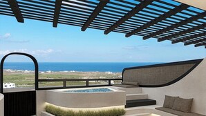 A modern outdoor seating area with a pool, overlooking a coastal landscape. - Mamay Hotel (Santorini)