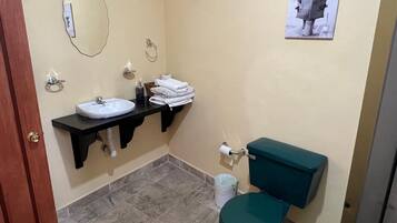 Une salle de bain équipée d’un lavabo, de toilettes et d’un porte-serviettes.