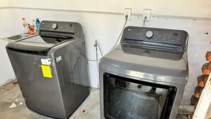 A laundry room with a washing machine and dryer, a power outlet, and a water pipe. - Suites el Ángel (Tuxtla Gutiérrez)