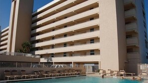 Et hotel med flere etager og et poolområde.