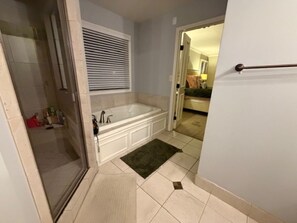 Et badeværelse med badekar, bruser og toilet.