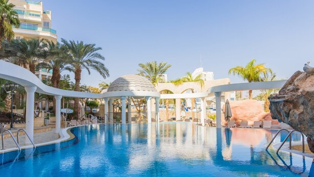 A swimming pool with a gazebo, palm trees, and a rocky landscape. - Mamad Bright Eilat escape with balcony and pool (Eilat)