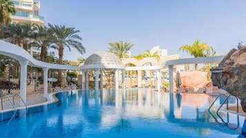 A swimming pool with lounge chairs and a gazebo.