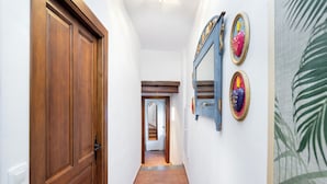 A hallway with wooden doors, a tiled floor, and wall-mounted mirrors. - The Crown (1stRight) (Granada)