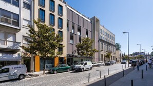 A street view with modern buildings, parked cars, and pedestrians. - 196 Andrade Corvo Collection by Minhos Guest (Braga)
