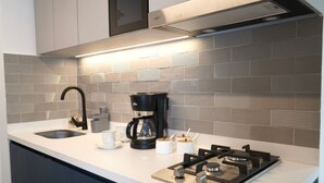 Une cuisine moderne équipée d’une cuisinière à gaz, d’une machine à café et d’un évier.