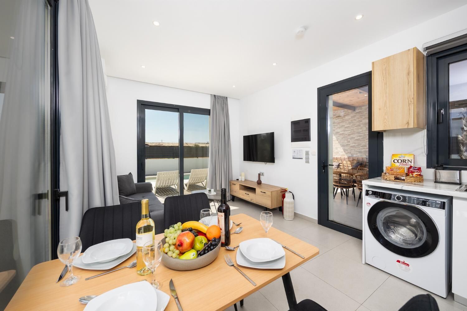 Une chambre d’hôtel moderne dotée d’un coin repas, d’une cuisine et d’un balcon avec vue.