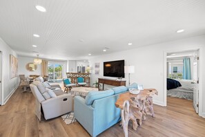 A spacious living area with a sofa, dining table, and a TV.
