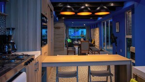 Una cocina moderna con barra, armarios de madera y un comedor con vistas.