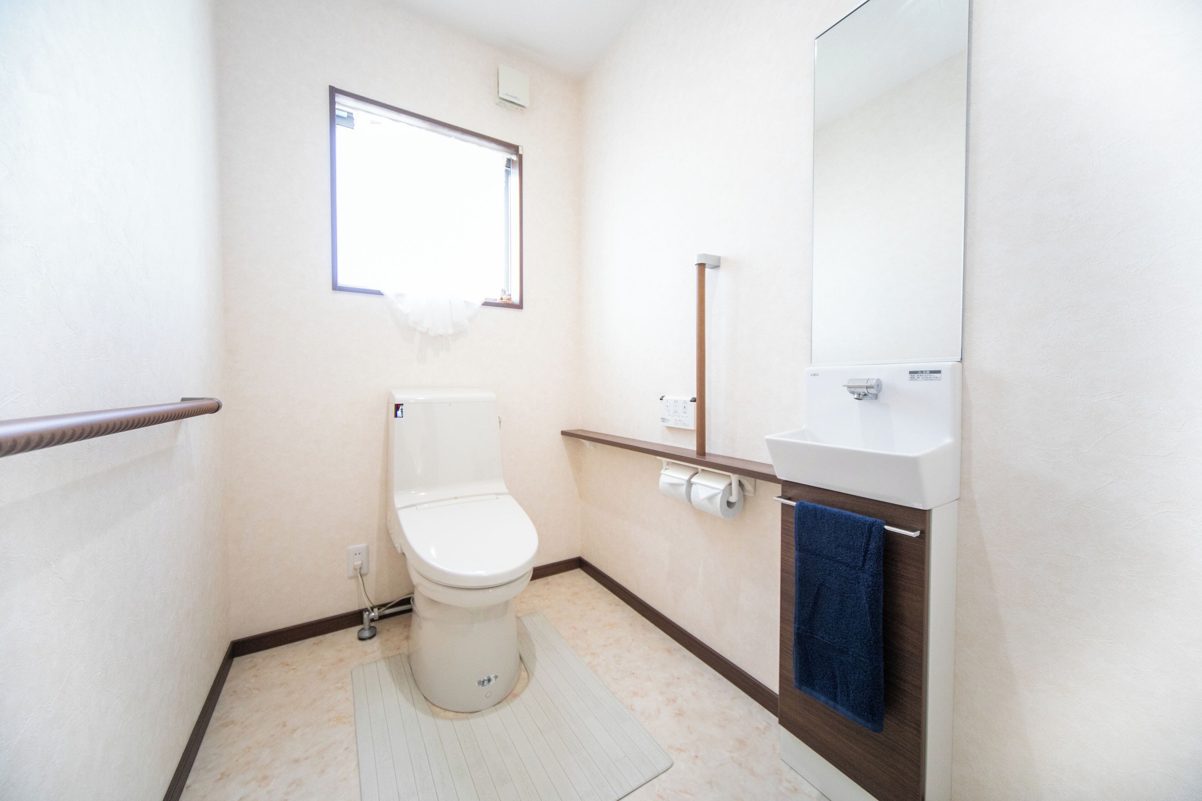 Een kleine, schone badkamer met toilet, wastafel en spiegel.