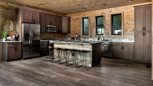 Une cuisine moderne avec des murs en bois, des appareils électroménagers en acier inoxydable et un coin bar.