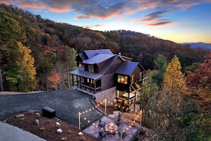 Ein modernes Haus mit einer großen Terrasse, umgeben von bewaldeter Landschaft.