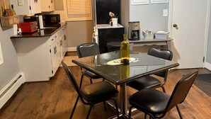 A compact kitchen with white cabinets, a microwave, and a coffee maker.